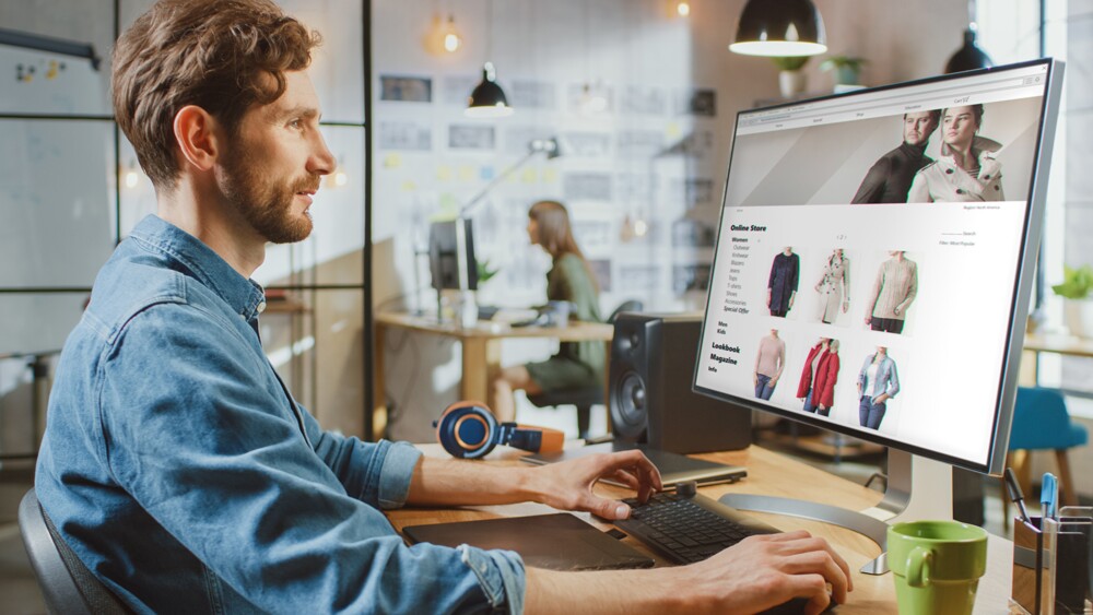 Person schaut Kleidung auf einem Computer